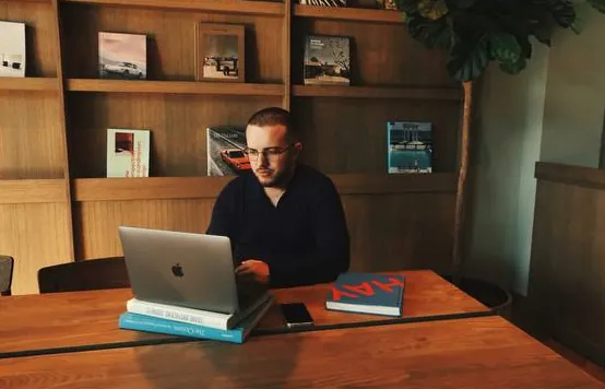 Yurii working on a laptop at a wooden desk